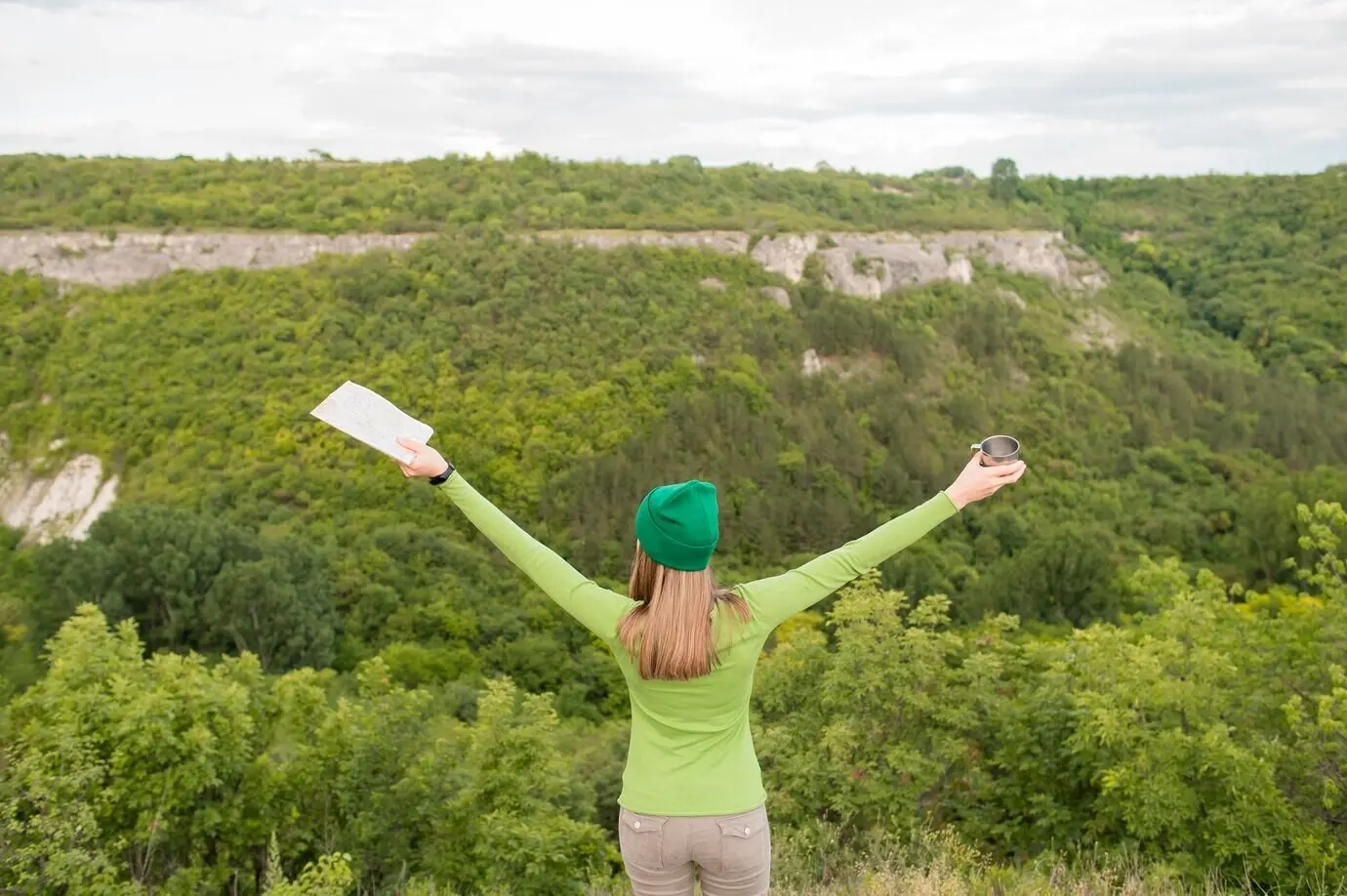 Rückenansicht eines jungen Reisenden, der sich freut, draußen zu sein.