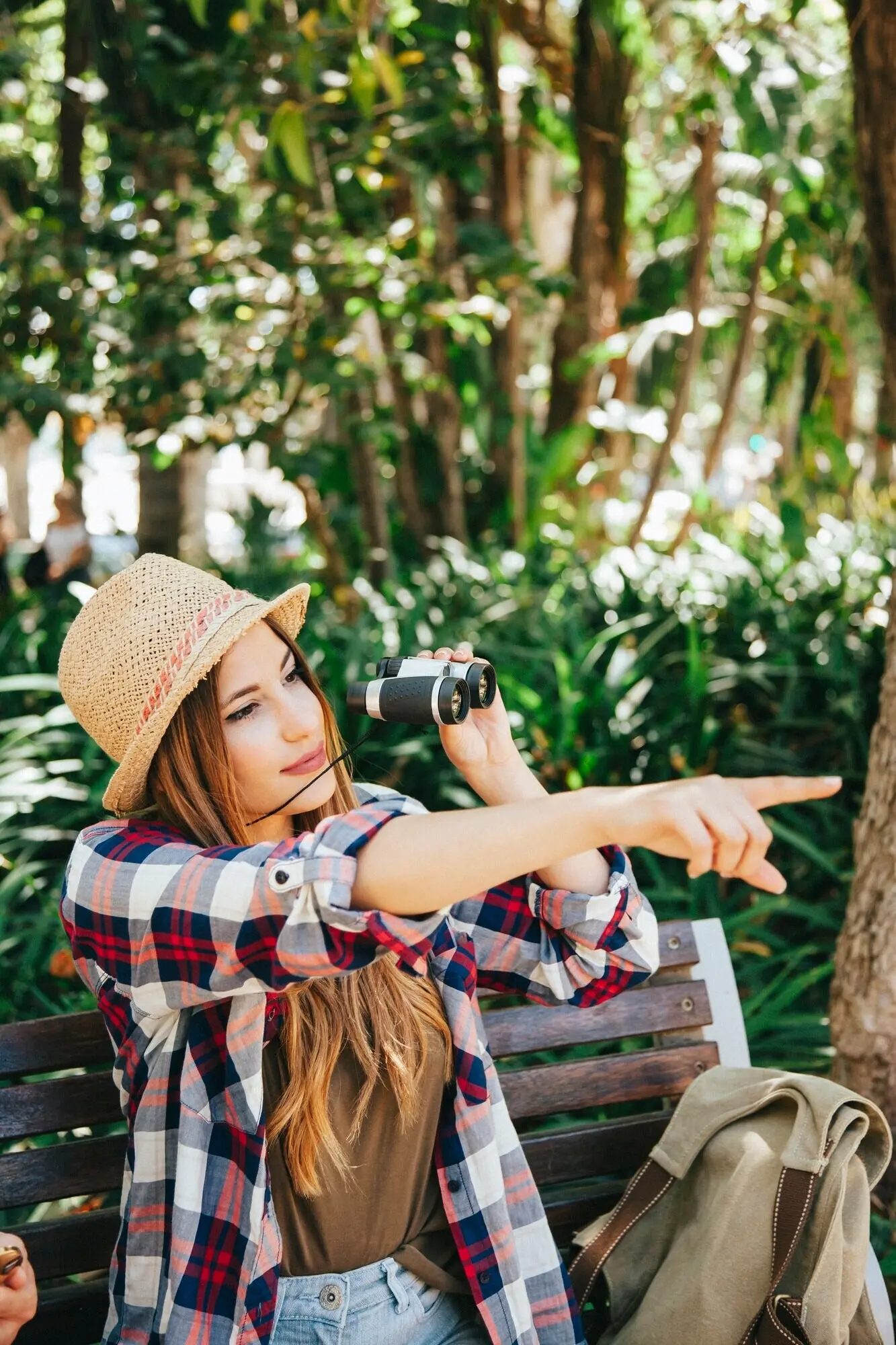 Mit einem Fernglas posierender Reisender.